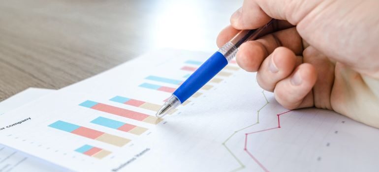 Someone's hand drawing on graphs.