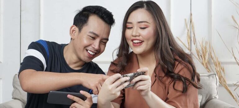 Couple researching ways inbound marketing can enhance sales for moving companies on their phones