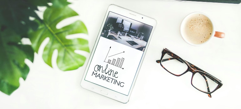 White desk with a tablet on it with a heading saying "ONLINE MARKETING"
