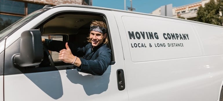 A person in a moving truck giving a thumbs up